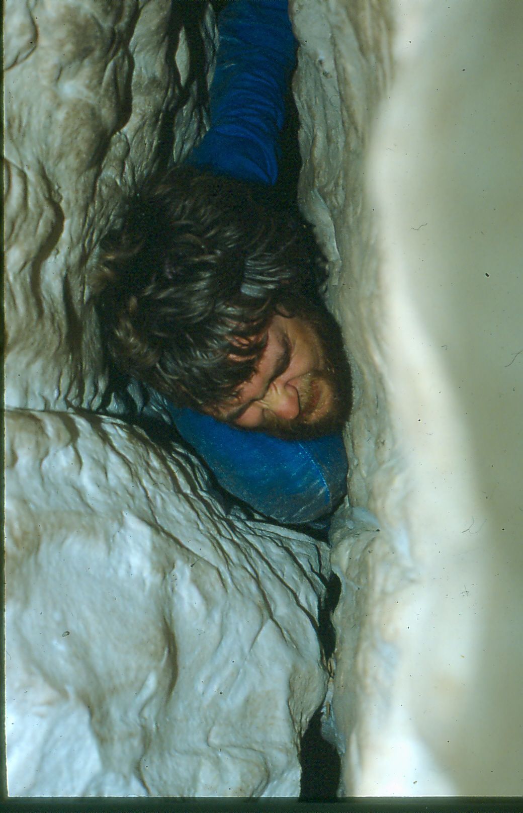 Dave Crombie squeezing through end of Ronan's Well cave